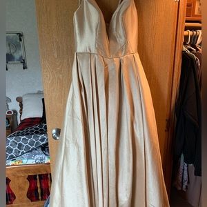 Long formal dress with pockets and is tight on top but flows on the bottom.